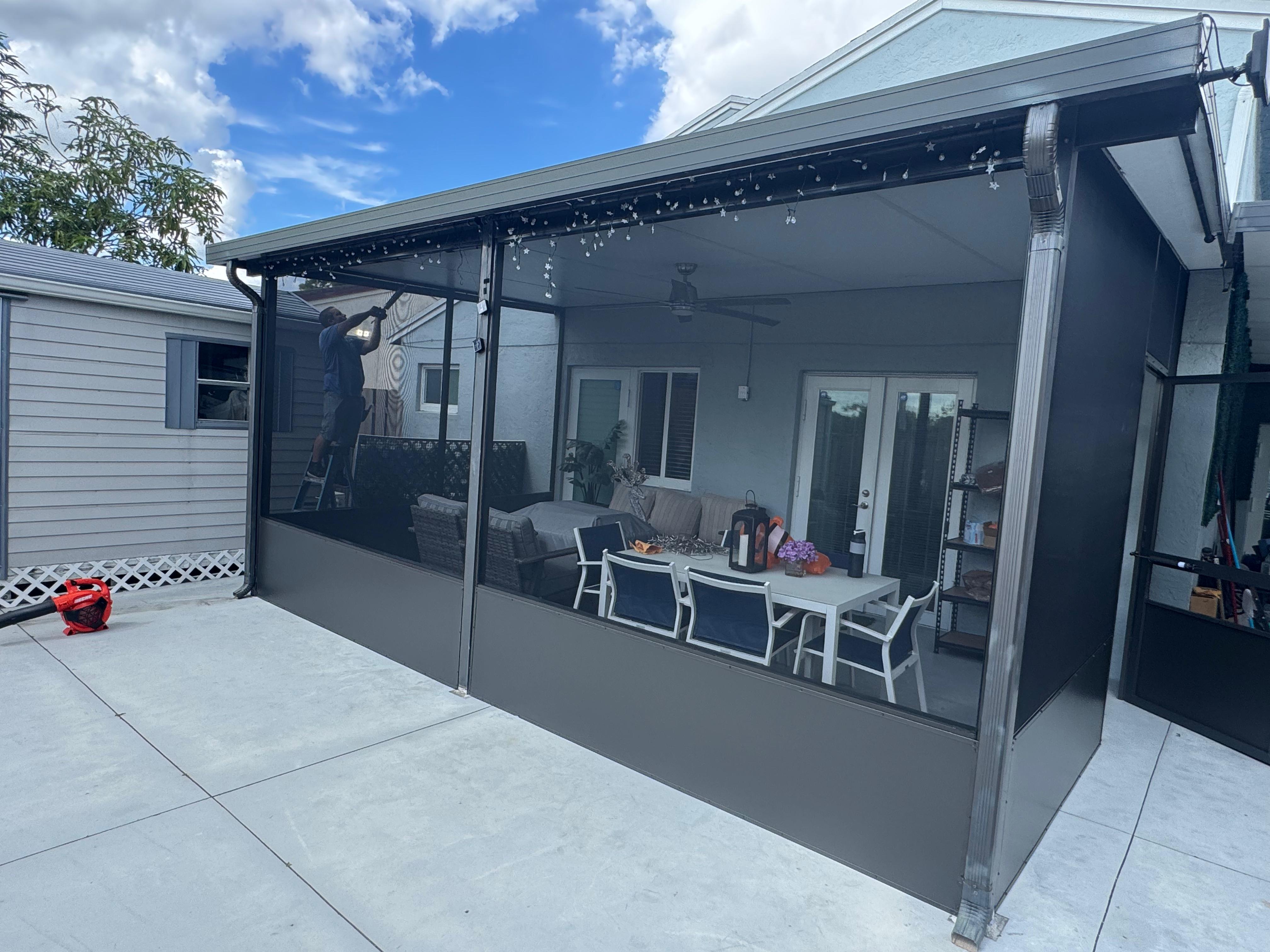 Completed patio screen room — charcoal aluminum frame, screens installed, South Florida