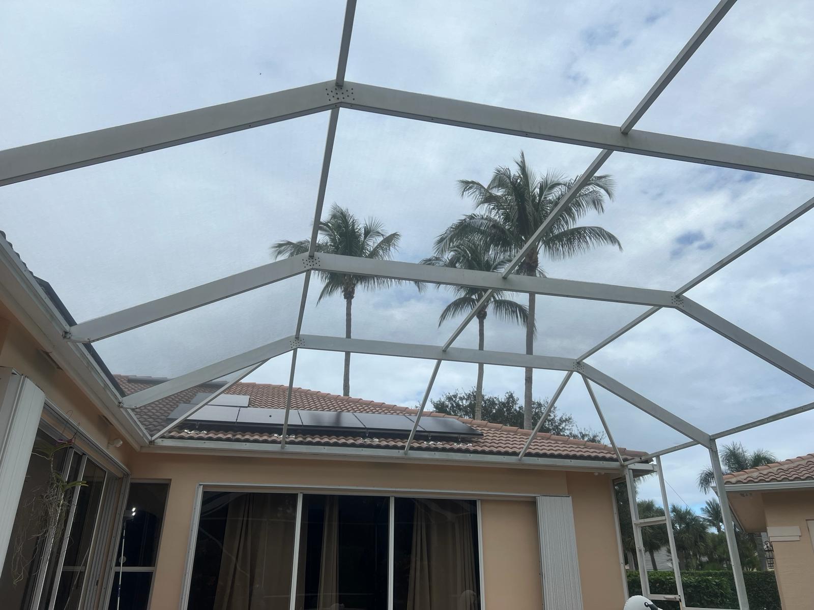 Completed pool enclosure rescreen — fresh new screen panels installed, interior view looking up