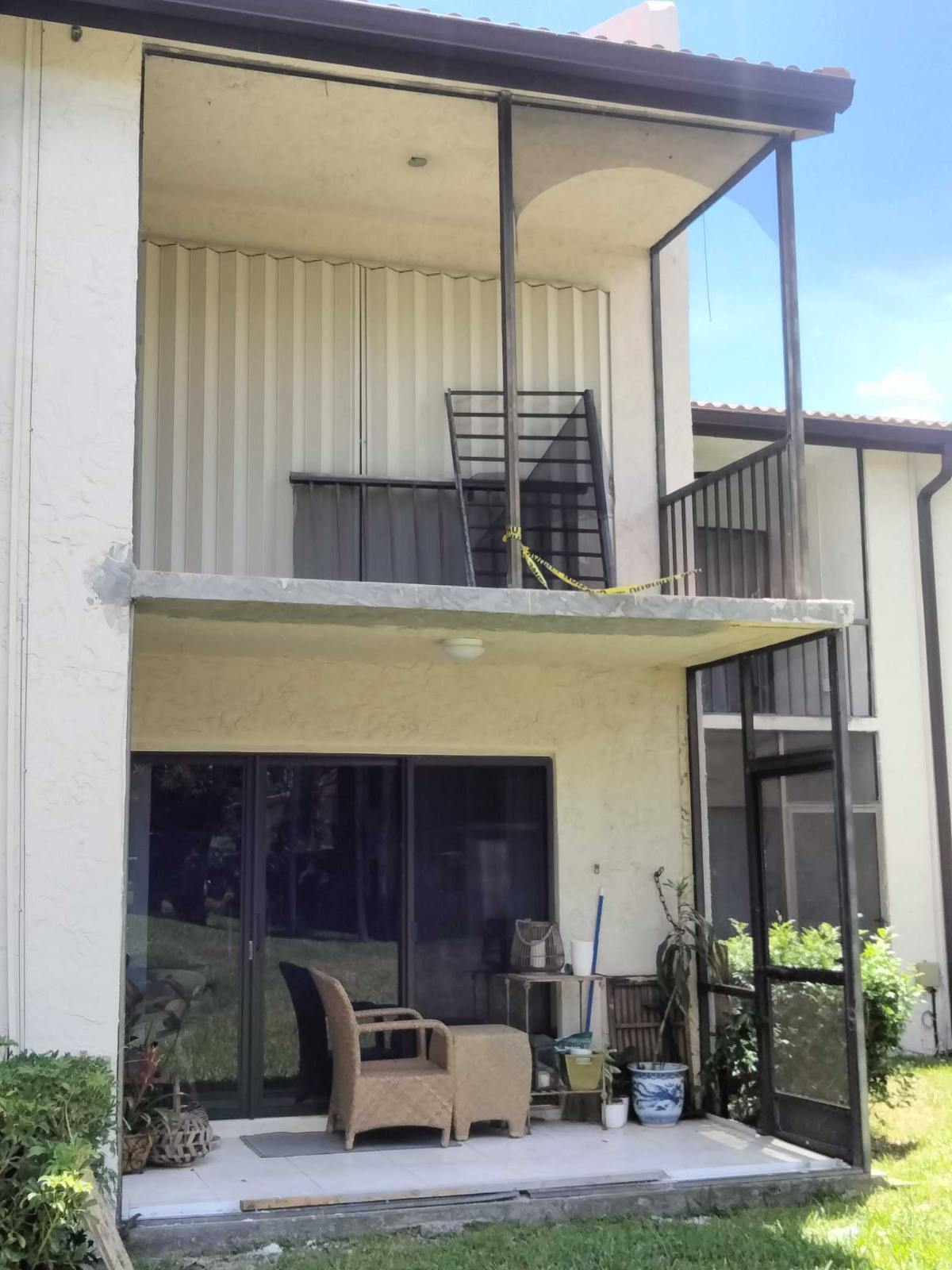 Condo building before rescreening — old, worn screen enclosures on exterior units