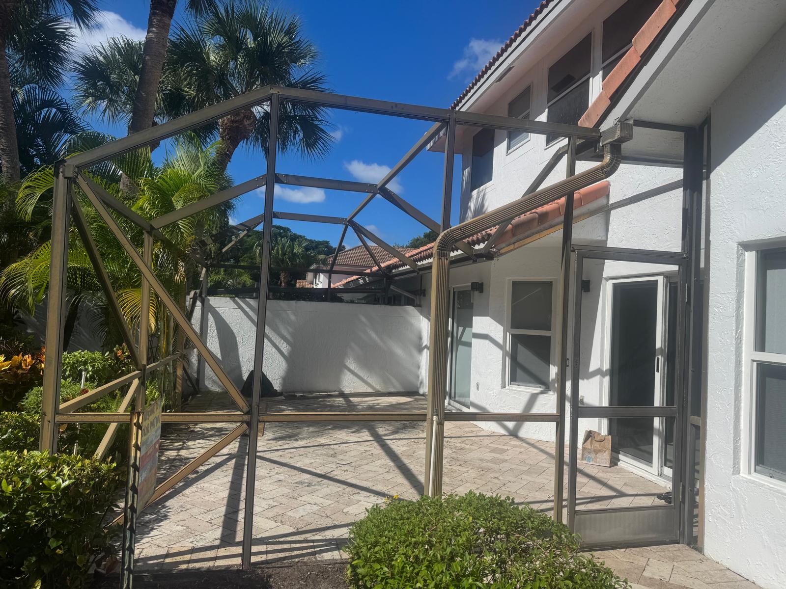 Pool enclosure frame before rescreening — bare aluminum structure, no screens, Boca Raton