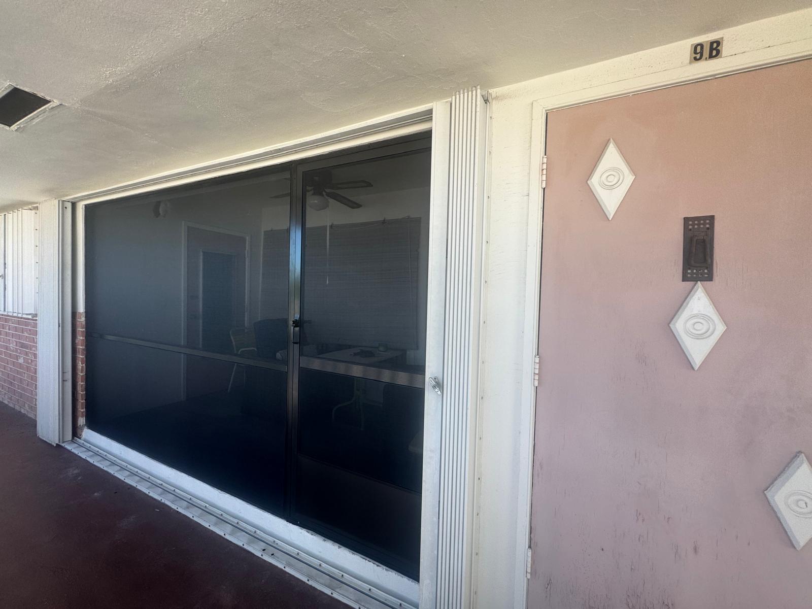 Condo unit with fresh dark screen panels installed — HOA rescreening project, Pembroke Pines
